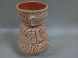 a small vase with a design on it sitting on a table