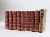 plusieurs vieux livres sont alignés sur une surface blanche