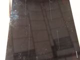 une photo d'une plaque de cuisson noire dans un carton
