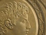 an image of a gold medallion with a man ' s head in the center