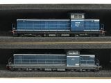 deux trains bleus posés dans une boîte sur les rails