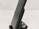 a close up of a cell phone on a stand on a table