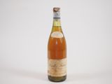 an old bottle of wine sitting on top of a white surface