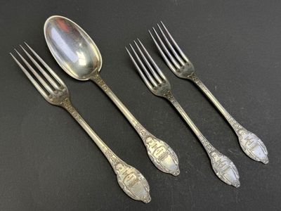 four silver spoons and a fork on a black surface