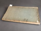 an old book sitting on top of a table next to a piece of paper