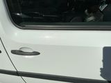 un homme assis dans une voiture, un téléphone portable à la main