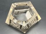 a clear glass ashtray with a design on it