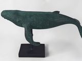 sculpture en bronze représentant une baleine à bosse sur un socle noir
