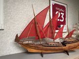 une maquette en bois d'un voilier posée sur une étagère