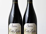 deux bouteilles de vin rouge posées l'une à côté de l'autre sur une table en bois