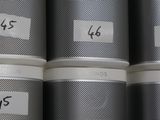five tins with labels on them sitting on a shelf