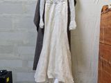 a wedding dress hanging on a clothes rack in a room