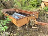 a rusted out boat sitting in the middle of the woods