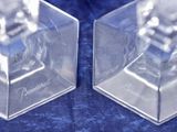 two crystal cubes that are sitting on a blue surface