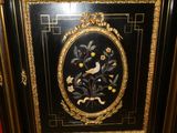 a black and gold cabinet with a bird and flowers on it
