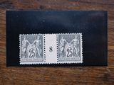 two stamps on a black envelope on a wooden table