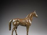 bronze statue of a horse standing on a wooden base