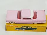 pink toy car sitting on top of a yellow box on a white surface
