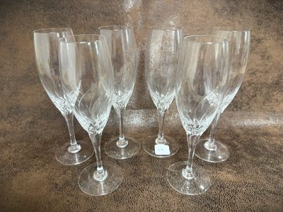 four empty wine glasses sitting on top of a table next to each other