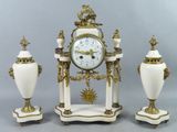 trois vases blancs et une horloge posés sur une table