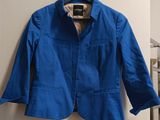 blue jacket hanging on a hanger in a room
