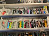many pens and pencils that are on the shelves