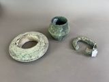 two pieces of pottery sitting on a table next to each other