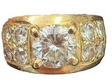 an image of a gold ring with a large diamond surrounded by smaller diamonds