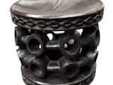 a small wooden stool with a lot of holes on it