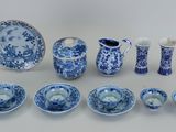 Plusieurs pièces de porcelaine bleue et blanche sont disposées sur une table