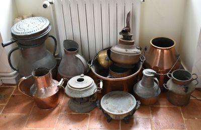 de nombreuses casseroles et poêles posées sur le sol à côté d'un radiateur