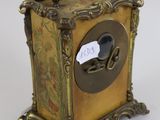 a gold clock with a black face on a white background