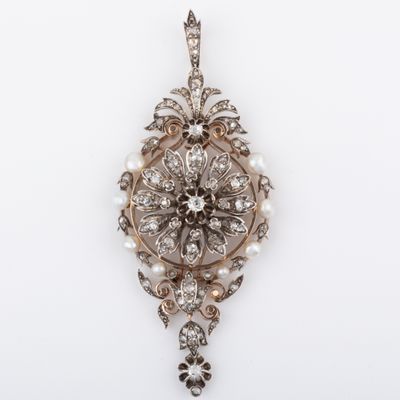 a close up of a diamond and pearl pendant on a white background