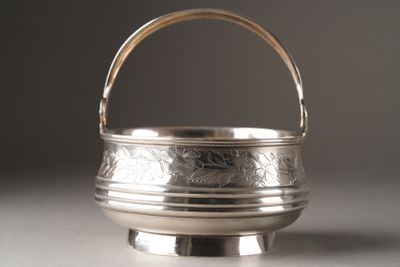 a small silver bowl with a handle on a table