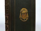 an old black book with a gold emblem on the cover