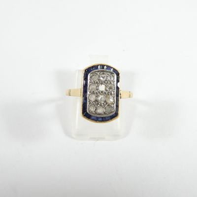 gros plan d'une bague en diamant et saphir sur une surface blanche