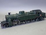 un petit train sur une surface blanche, avec un fond gris