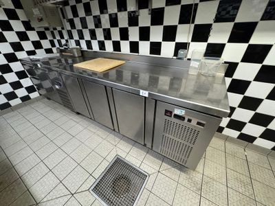 a kitchen with a checkered wall and stainless steel counter tops