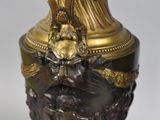 a gold vase with a statue on top of it