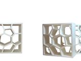 deux boîtes blanches ornées de motifs géométriques, posées sur une surface blanche