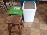 a small kitchen with a table and chairs and a trash can
