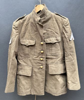 une vieille veste militaire suspendue à un cintre accroché au mur