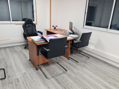 un bureau avec deux chaises et un ordinateur dessus