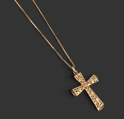 un pendentif en forme de croix en or avec une chaîne, sur fond noir