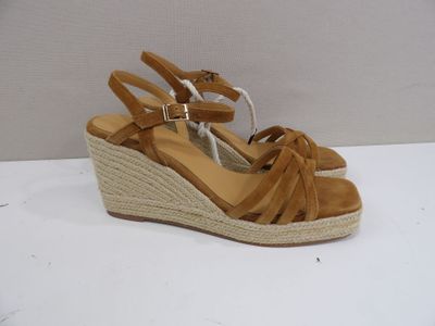 sandales à talon compensé de couleur beige, avec des lanières tressées, sur un fond blanc