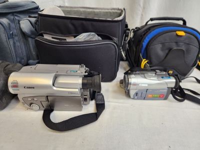 many different types of cameras and accessories laid out on a table