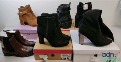 Plusieurs paires de bottes pour femmes sont empilées sur des cartons