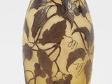 un vase noir et jaune posé sur une surface blanche