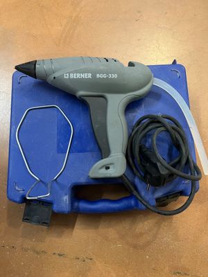 a close up of a corded hot glue gun on a table