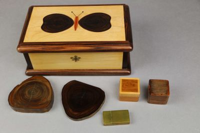 a small wooden box with a butterfly on top of it